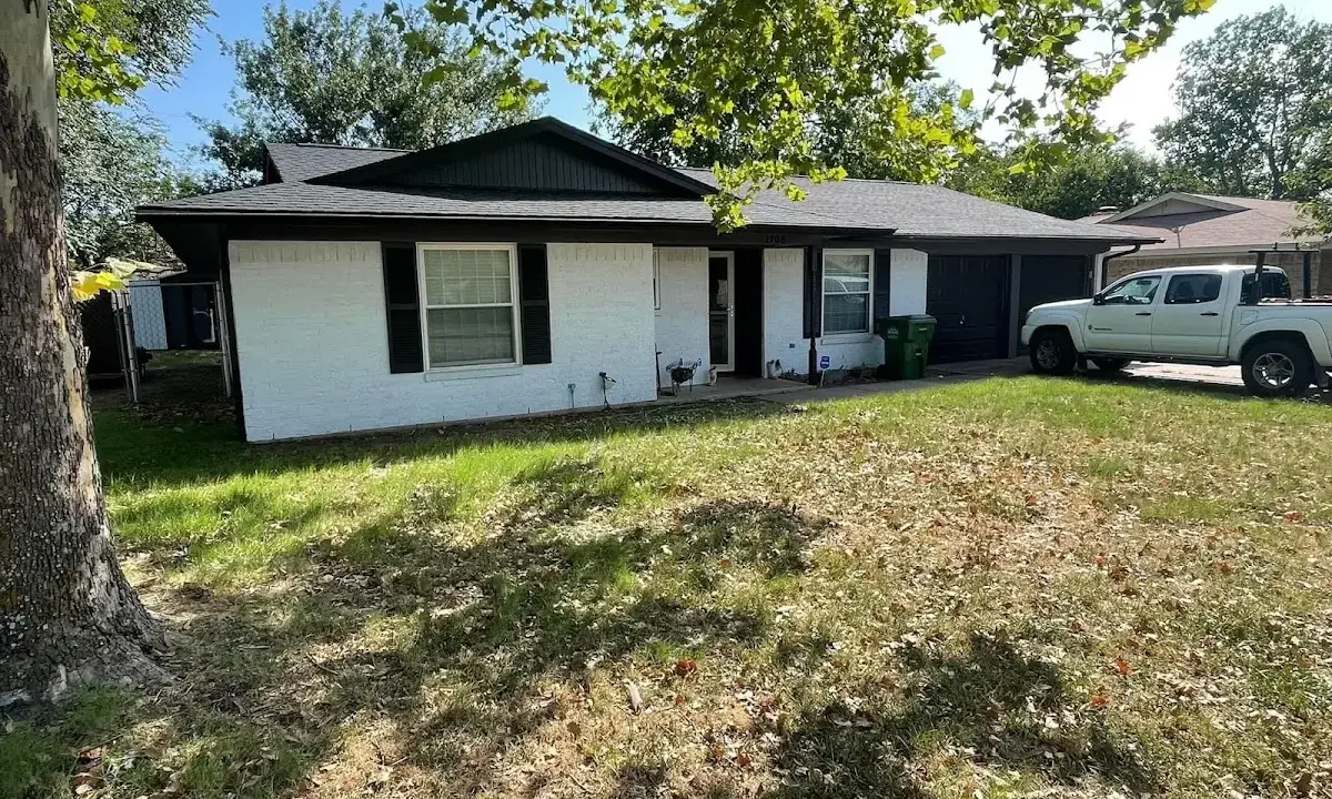 Professional roofing crew working on a residential roof in Paola